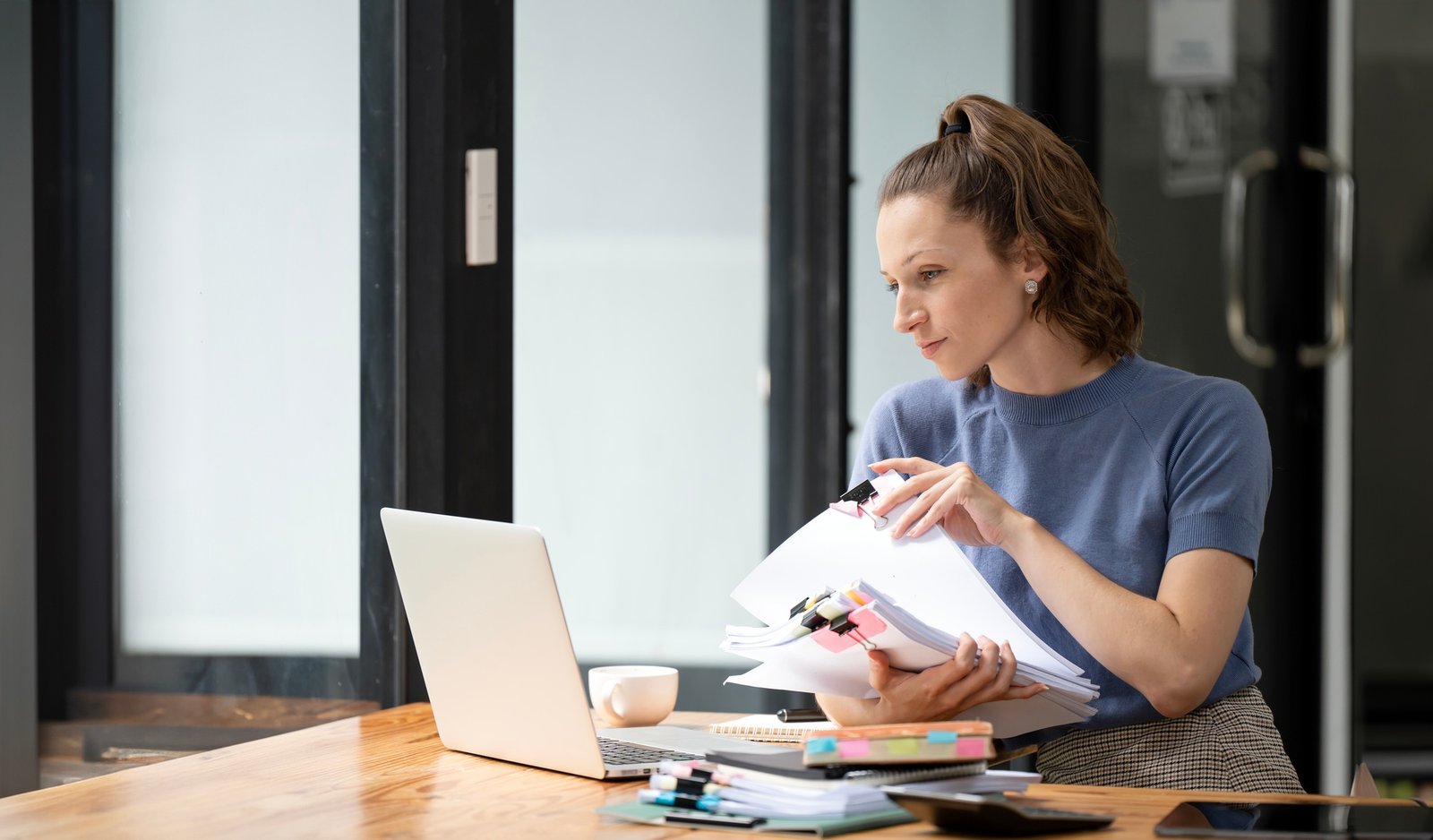 Business woman holding accounting bookkeeping documents checking financial data report