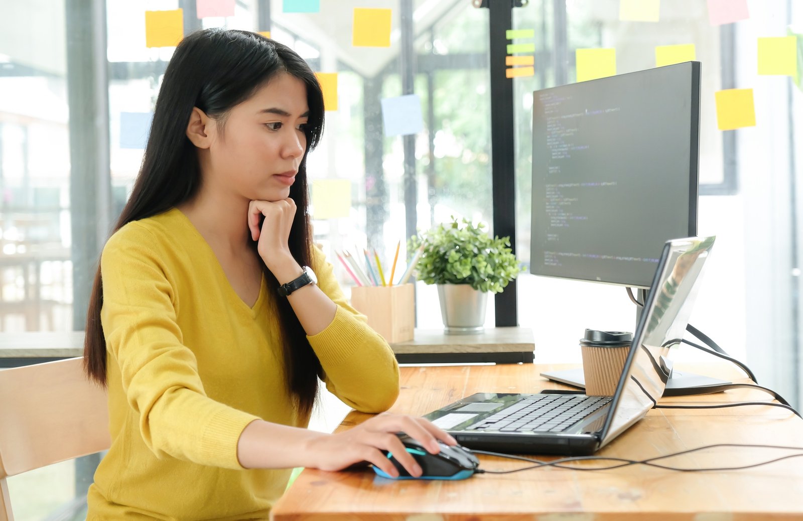Female programmer using laptop to create programs for clients.