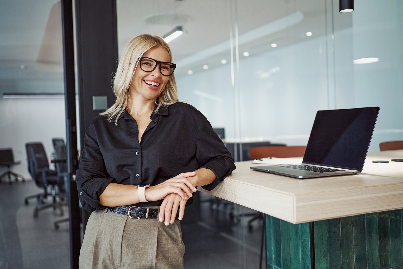 A Professional Woman Working in an Office Environment Positioned with Her Laptop, Engaging in Tasks