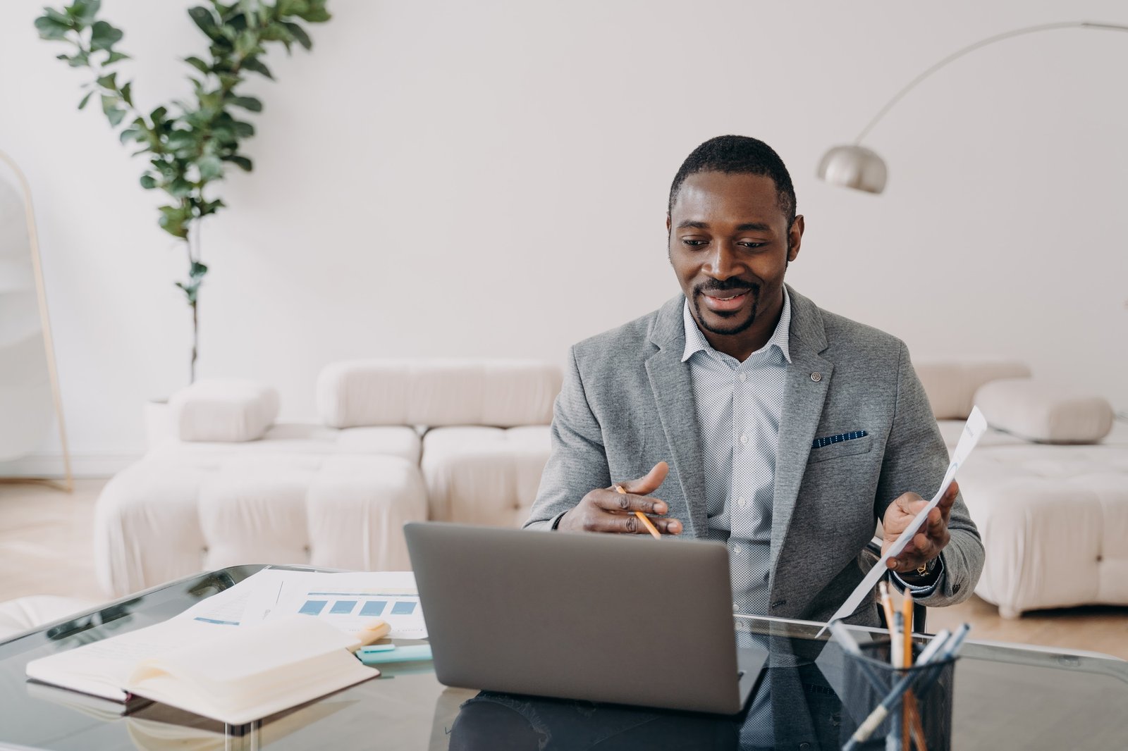 Relaxed professional man going over financial charts on his laptop in a bright home office.