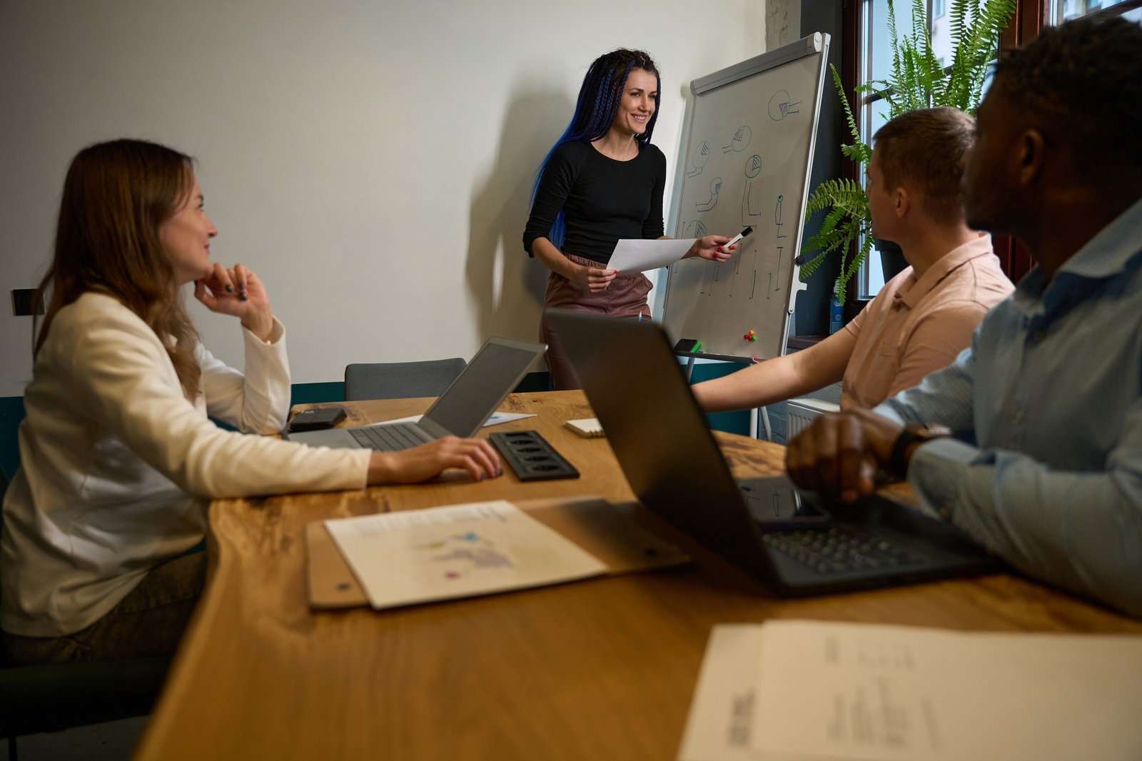 Office manager conducting business training for multiethnic employees